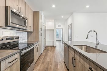 A modern kitchen with wooden cabinets and stainless steel appliances.